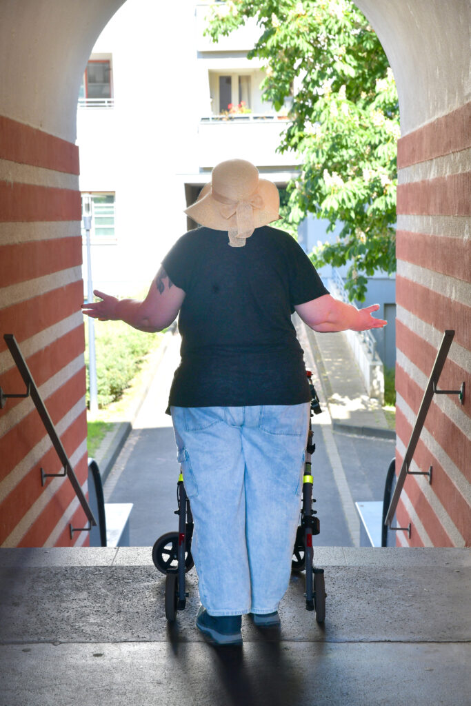 Ich von hinten vor einer Treppe die ich mit dem Rollator nicht schaffe
