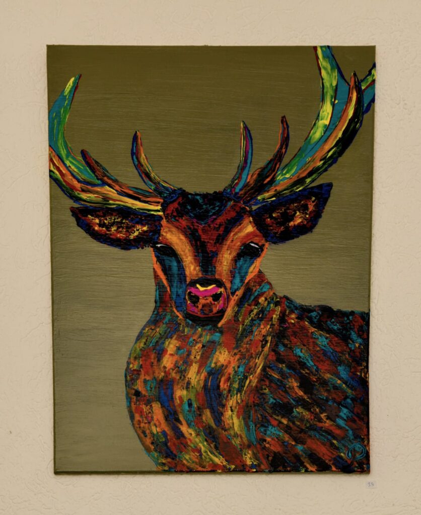 ein sehr buntgefleckter Hirsch auf grauem Hintergrund