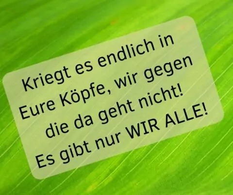 Schrift auf grünem Grund: Kriegt es endlich in eure Köpfe, wir gegen die da geht nicht! Es gibt nur WIR ALLE!