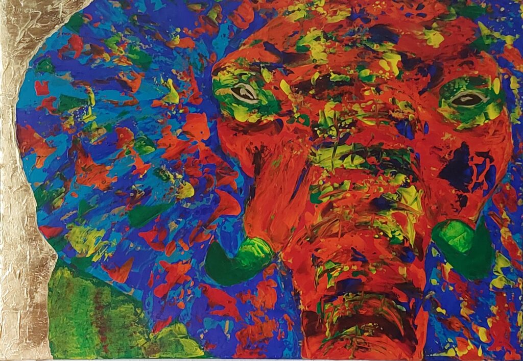 Ein Elefantenkopf von vorne mit roter, blauer und gelber Farbe gemalt