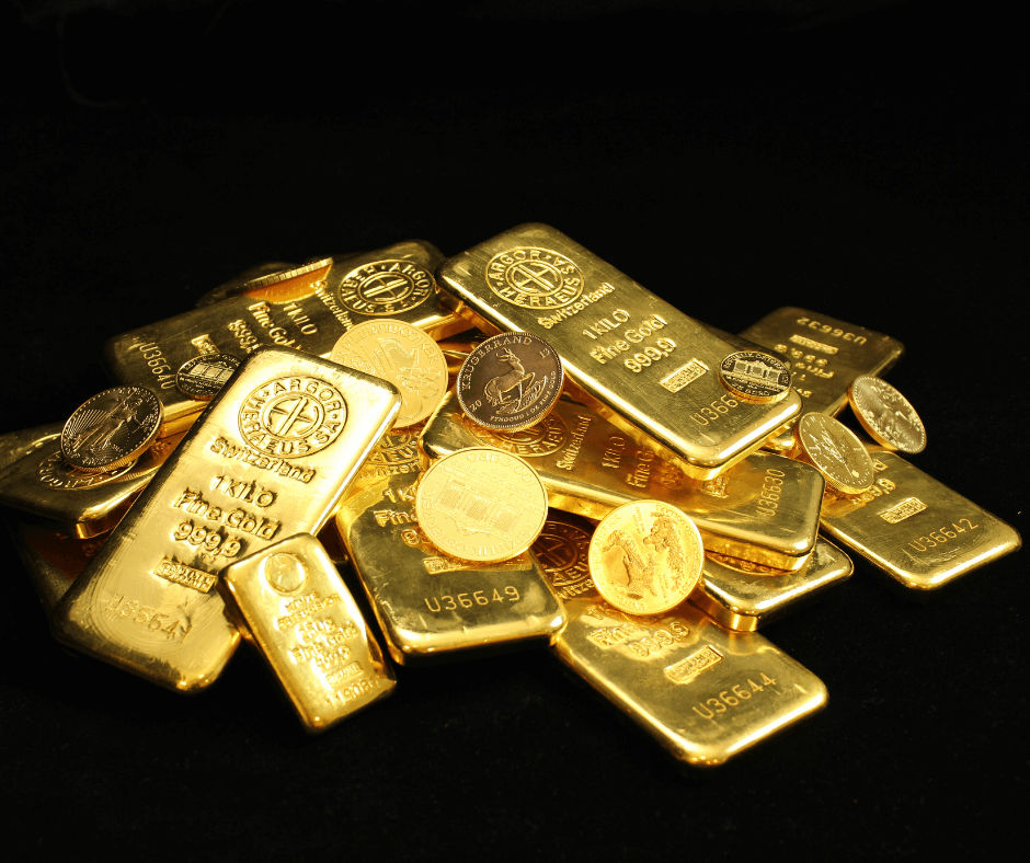 Goldbarren und Goldmünzen aufgehäuft vor einem schwarzen Hintergrund