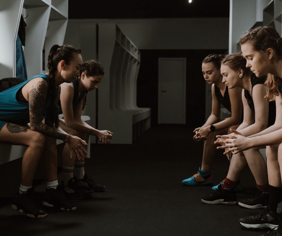Junge FRauen, anscheinend eine Sportmannschaft im Umkleideraum