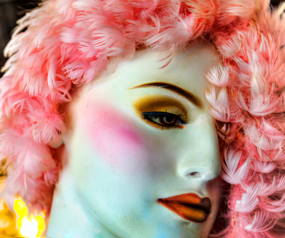 eine Schaufensterpuppe, grell geschminkt mit Pinkfarbenem Haar