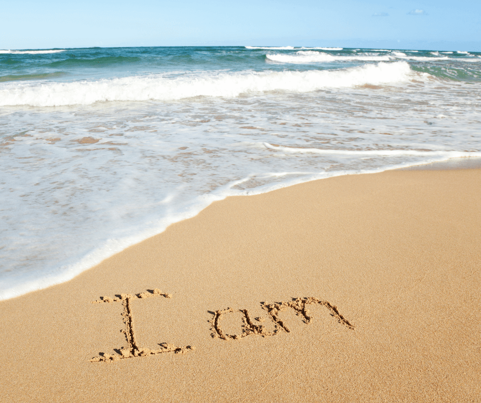 Ein Strand, im Sand ist "I am " geschrieben
