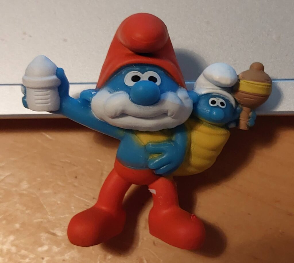 Papa Schlumpf als Minifigur, mit Baby und Fläschchen in der Hand, auch hier ist Politik und Business zusammen